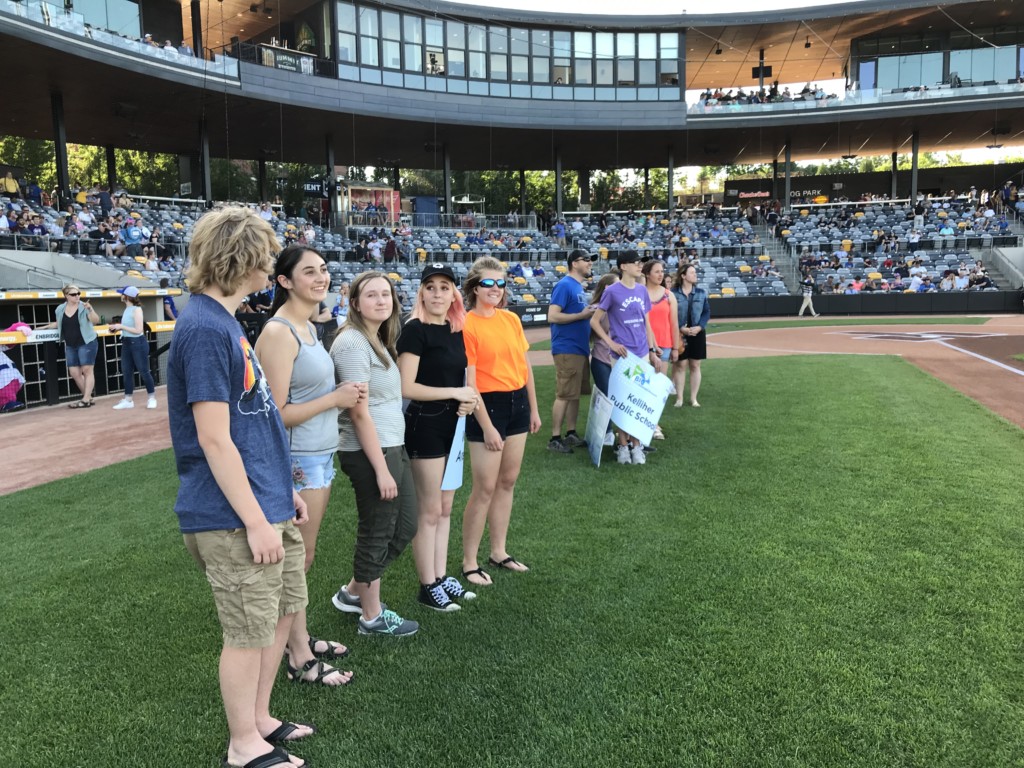 Students from White Bear Lake Area High School wait on field. 